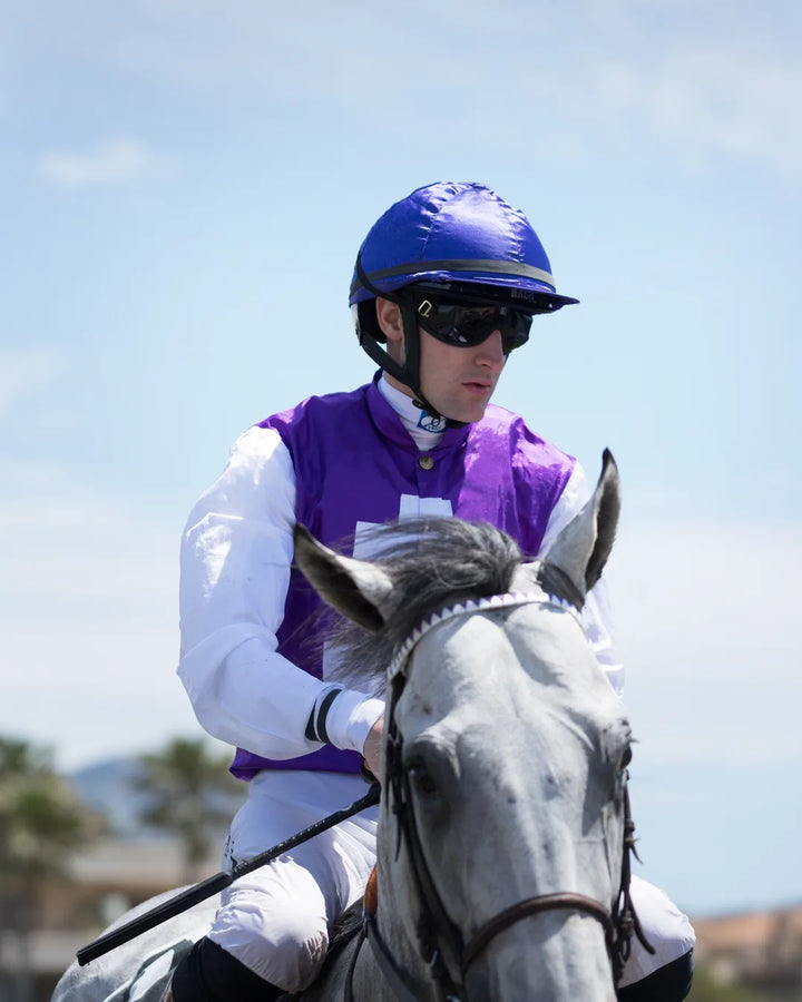 Le jockey Marvin Grandin sur un cheval gris, équipé du casque d&